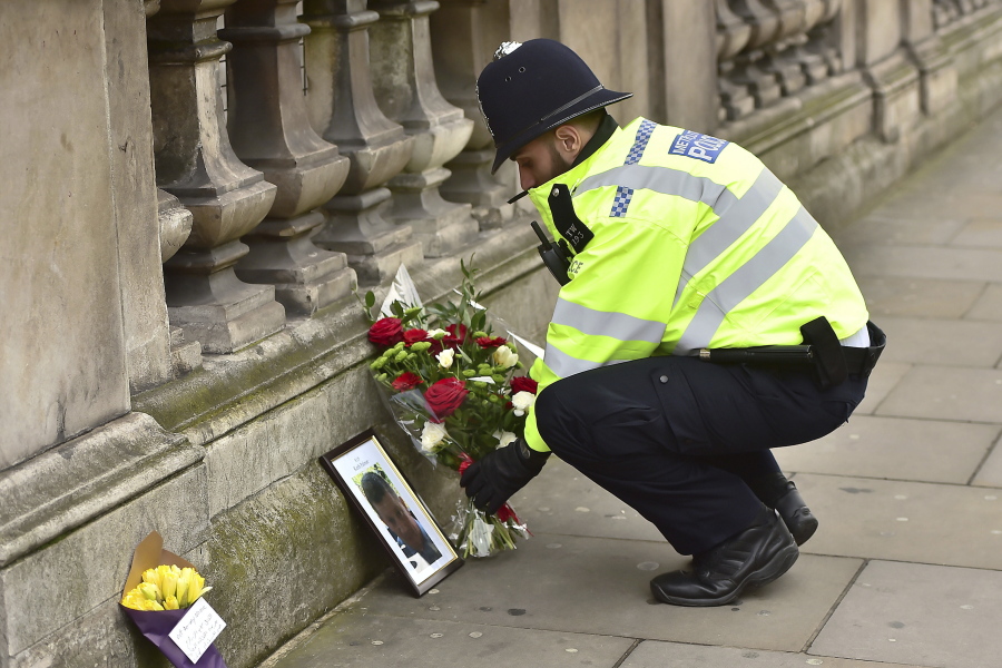 A police officer places flowers and a photo of fellow police officer Keith Palmer, who was killed in Wednesday&#039;s attack, on Whitehall near the Houses of Parliament in London, Thursday March 23, 2017. On Wednesday a knife-wielding man went on a deadly rampage, first driving a car into pedestrians then stabbing a police officer to death before being fatally shot by police within Parliament&#039;s grounds in London. Ten people have been arrested.