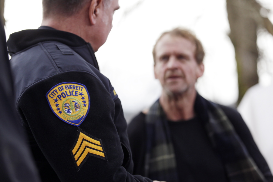 Police Sgt. Mike Braley, left, talks with Parker O&#039;Neall, a homeless man living in the woods in the outskirts of Everett. Everett Mayor Ray Stephanson has spent thousands to clean up streets, hire social workers to ride along with police officers and build permanent housing for the chronically homeless, many with addiction problems.