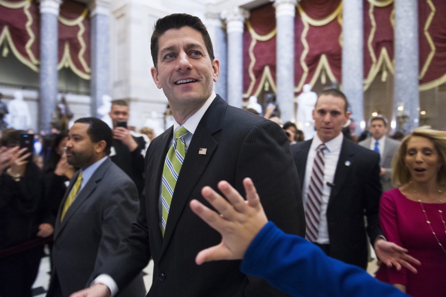 House Speaker Paul Ryan, R-Wis., passes a waving tourist Friday as he walks from the House Chamber to his office on Capitol Hill in Washington, as the House nears a vote on their health care overhaul.