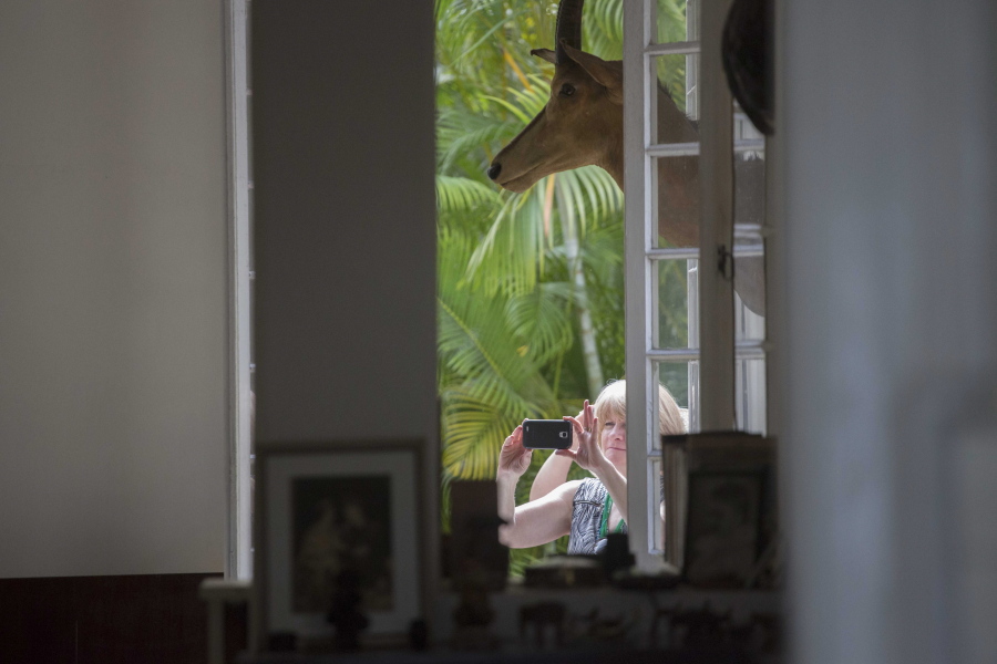 A tourist takes pictures of the home of late U.S. writer Ernest Hemingway, now the Finca Vigia in Havana, Cuba. A rare poll of Cuban public opinion taken in late 2016 has found that most Cubans approve of normal relations with the United States and large majorities want more tourism and private business ownership.