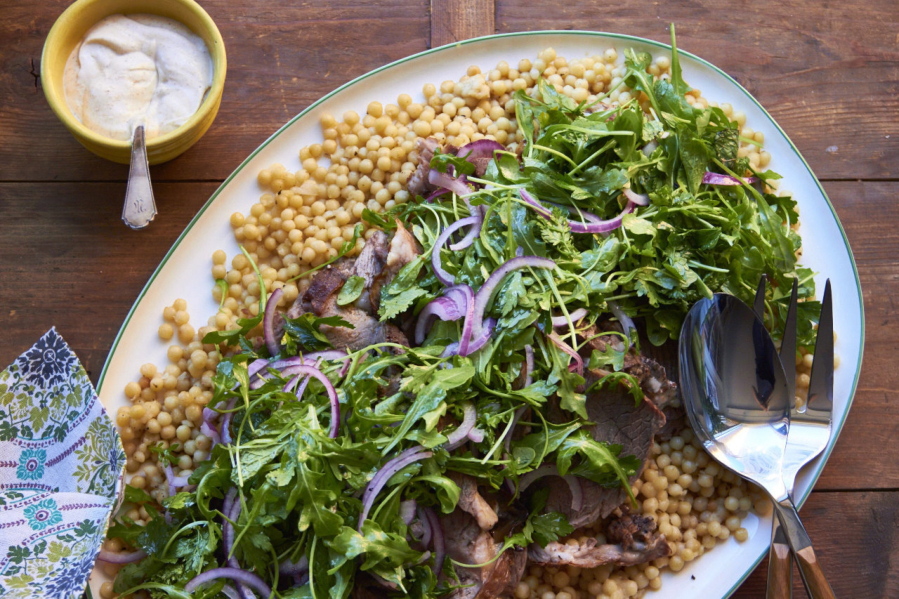Slow-cooked herbed leg of lamb with fresh herb and arugula salad (Mia via AP)