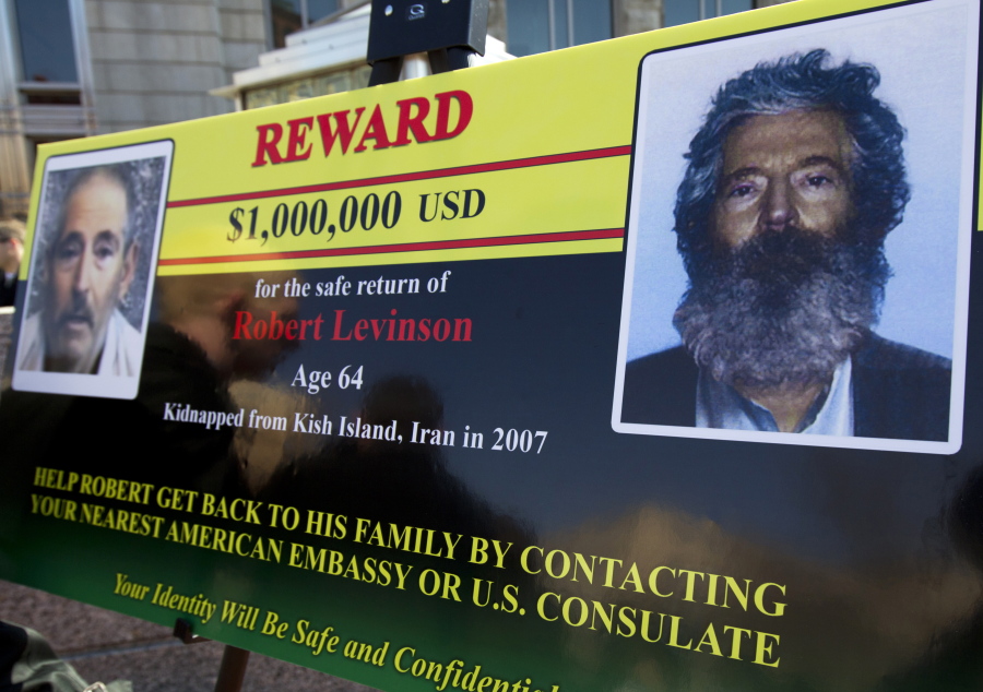 An FBI poster showing a composite image of former FBI agent Robert Levinson, right, of how he would look like now after five years in captivity, and an image, left, taken from the video, released by his kidnappers, in Washington during a news conference on March 6, 2012. The family of Levinson, who went missing in Iran a decade ago on an unauthorized CIA assignment, filed a lawsuit Tuesday against Iran. The lawsuit in U.S. federal court describes in detail offers by Iran to arrange for his release in exchange for a series of concessions, including for the return of a Revolutionary Guard general who defected to the West.