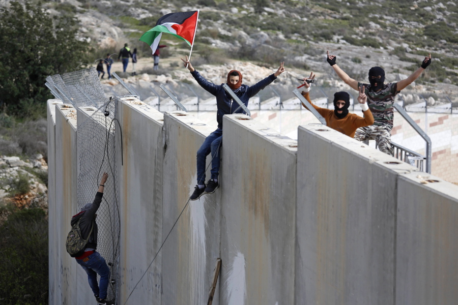 Palestinian protesters climb over the separation barrier with Israel on Monday during a demonstration marking the 12th anniversary of their campaign against Israel&#039;s separation barrier in the West Bank village of Bilin near Ramallah. Israeli Defense Minister Avigdor Lieberman said Monday that the U.S. notified Israel that imposing Israeli sovereignty over the West Bank would lead to an &quot;immediate crisis&quot; with the Trump administration.
