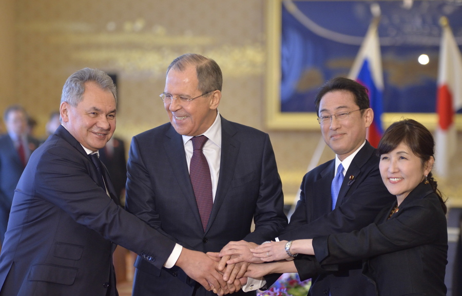 Russian Foreign Minister Sergei Lavrov, second left, Russian Defense Minister Sergei Shoigu, left, smile as they put hands together with Japanese Foreign Minister Fumio Kishida, second right, and Japanese Defense Minister Tomomi Inada during the two-plus-two meeting in Tokyo on Monday. The foreign and defense ministers from Japan and Russia met in Tokyo on Monday, with both sides expressing hope that discussions on joint development of islands claimed by both countries might help them move closer to resolving the territorial dispute preventing them from forging a peace treaty.