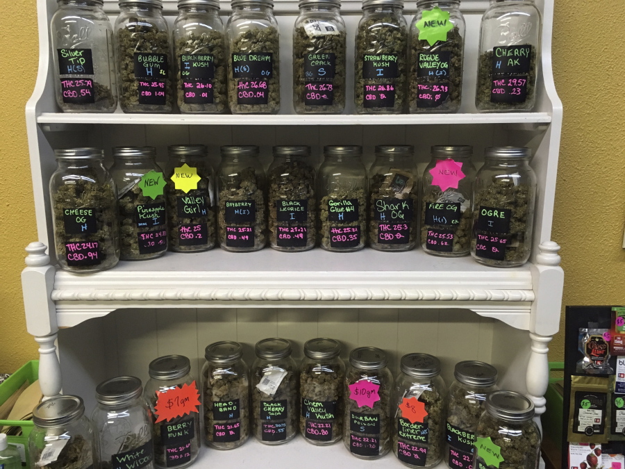 FILE--In this Sept. 27, 2016, file photo, different strains of marijuana are displayed in West Salem Cannabis, a marijuana shop in Salem, Ore. In Oregon, at least 12,500 jobs are attributed to legal recreational marijuana and in Oregon, Washington state and Colorado, marijuana tax revenues totaled $335 million in 2016.
