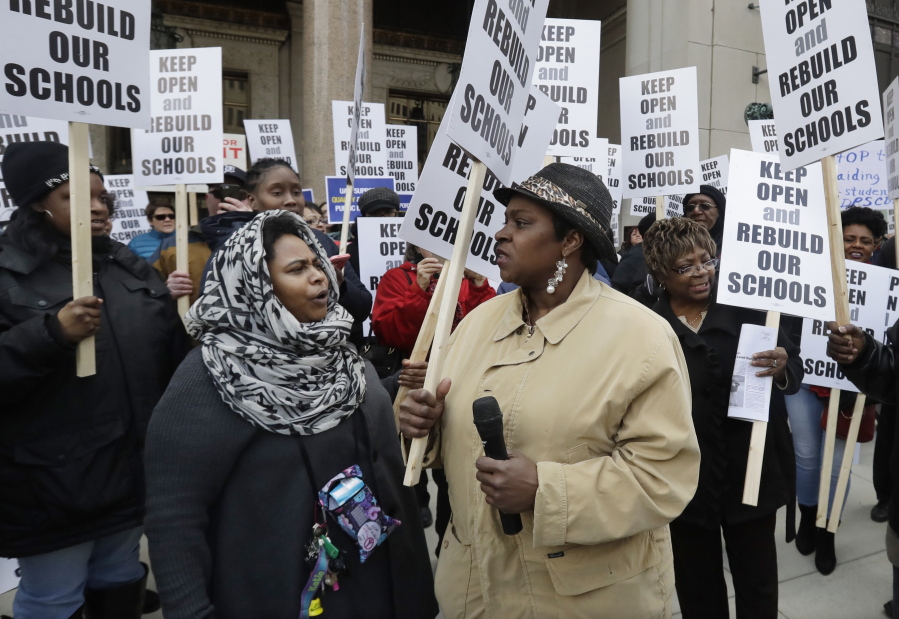 Roquesha O&#039;Neal, left, and Shoniqua Kemp participate in a rally in Detroit. Dozens protested Michigan&#039;s threat to close dozens of underperforming public schools in Detroit and several other cities. The plan is angering parents and frustrating educators faced with limited options to provide better learning.