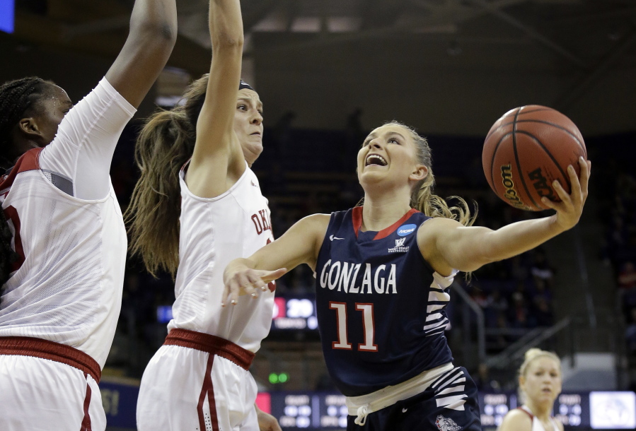 Gonzaga&#039;s Laura Stockton (11) drives the lane as Oklahoma&#039;s Vionise Pierre-Louis, left, and Maddie Manning defend during the first half of a first-round game in the NCAA women&#039;s college basketball tournament Saturday, March 18, 2017, in Seattle.
