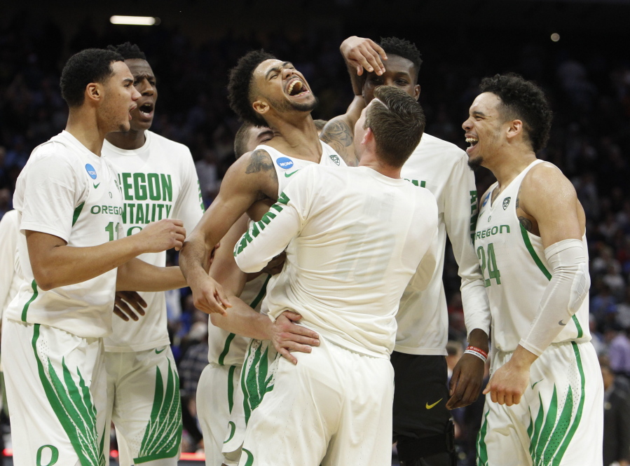 Oregon&#039;s Tyler Dorsey, center, celebrates with teammates after their second-round win over Rhode Island.