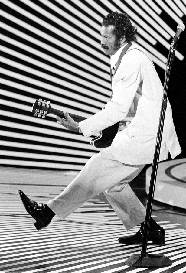 Guitarist and singer Chuck Berry performs his signature &quot;duck walk&quot; on stage in April 1980.