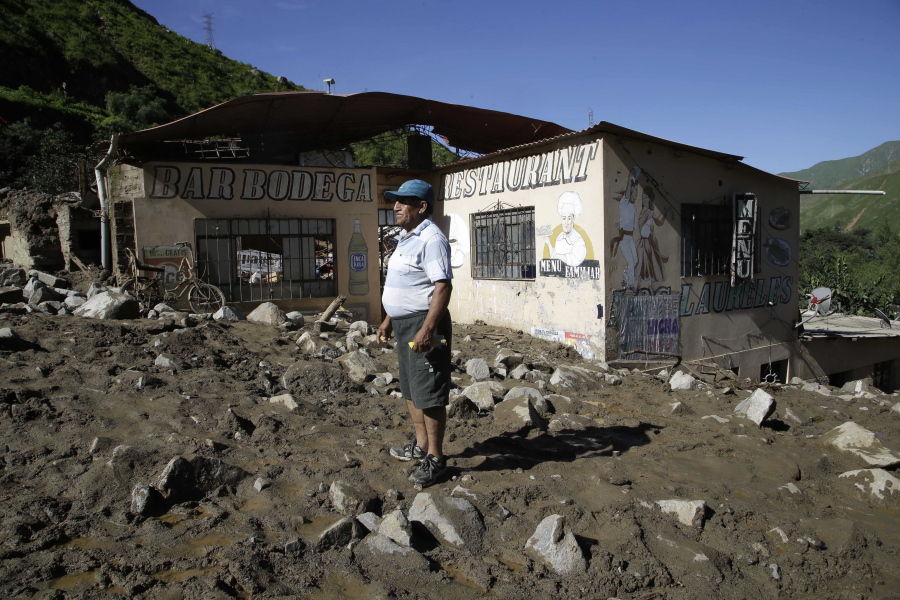 Flood survivor Juan de Dios stands in front of his destroyed home Friday in Barbablanca, Peru.