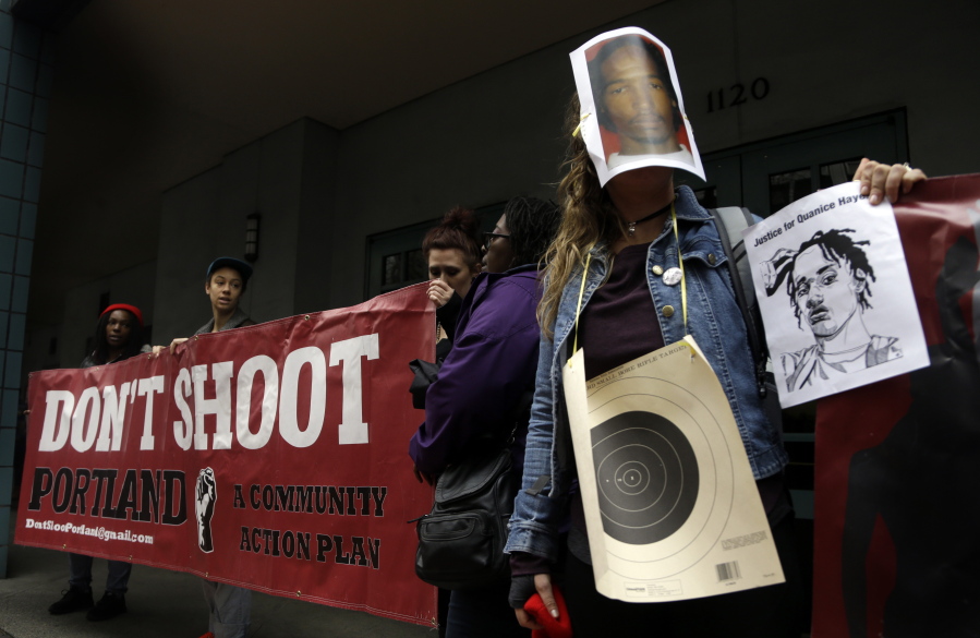 One person wears a bullseye and photo mask of Quanice Hayes during a press conference in Portland, Ore., Wednesday, March 22, 2017. Venus Hayes, the mother the 17-year-old Quanice Hayes, held the news conference after a grand jury declined to indict a Portland police officer on criminal charges in the Feb.