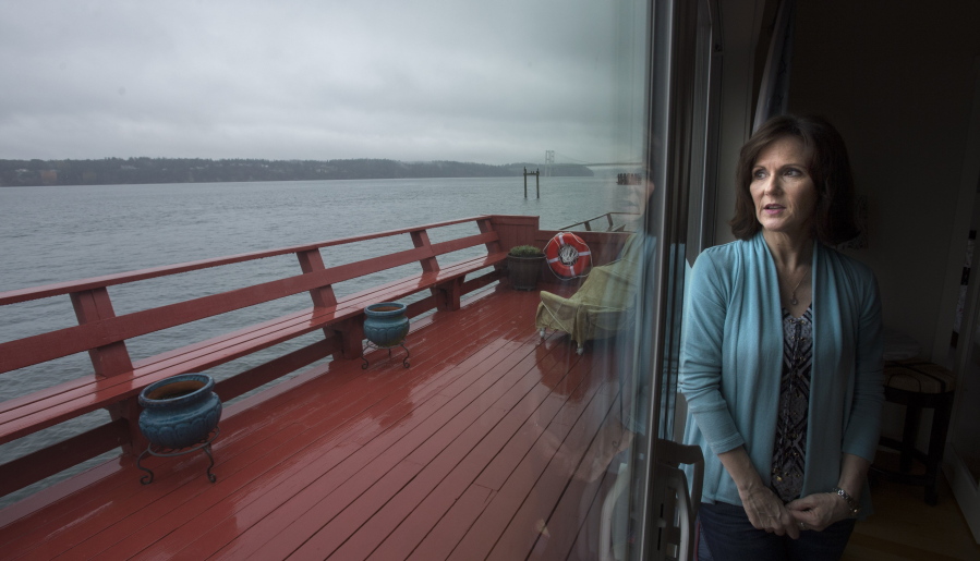 Julia Lundblad looks out of her living room at a view of Puget Sound at Titlow Beach in Tacoma on March 9. Because the small Washington community of Titlow Beach lies in such intimate proximity to the Puget Sound, homeowners with mortgages have to carry flood insurance. The cost of that insurance, if you can get it, can be exorbitant. Some homeowners said they've been told to expect their monthly premiums to see huge spikes over the next several years.