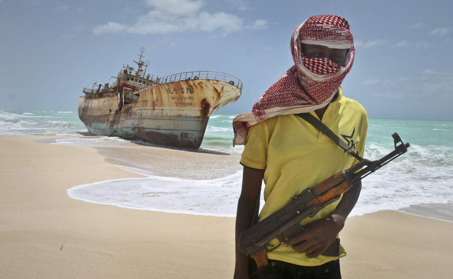 Masked and armed Somali pirate Hassan stands near a Taiwanese fishing vessel washed ashore after the pirates were paid a ransom and the crew were released in the once-bustling pirate den of Hobyo, Somalia, in 2012. Pirates have hijacked an oil tanker off the coast of Somalia, Somali officials and piracy experts said Tuesday, March 14, 2017, in the first hijacking of a large commercial vessel there since 2012.