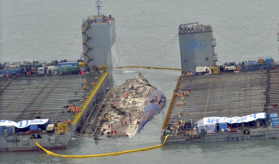Workers prepare to lift the sunken Sewol ferry, center, Thursday in waters off Jindo, South Korea.