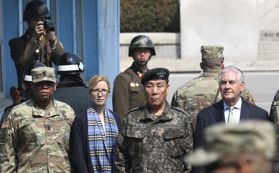 U.S. Secretary of State Rex Tillerson, right, stands with South Korean Deputy Commander of the Combined Force Command Gen. Leem Ho-young, second right, as two North Korean soldiers, top left and top center, look at the south side at the border village of Panmunjom, which has separated the two Koreas since the Korean War, South Korea, on Friday. Others are: Command Sgt. Maj. Steven L. Payton, left, of the United Nations Command, Combined Forces Command and United States Forces Korea and U.S. Secretary of State&#039;s Chief of Staff Margaret Peterlin, second left.