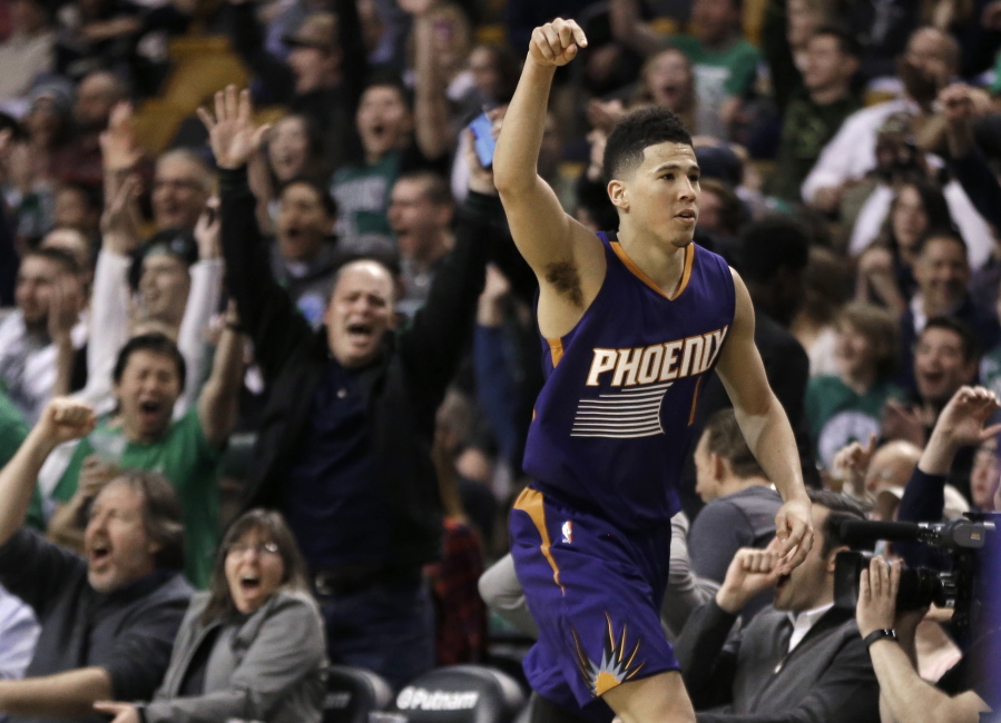 Phoenix Suns guard Devin Booker gestures after he scored a basket, as fans cheer him at TD Garden in the fourth quarter of the Suns&#039; 130-120 loss to Boston.