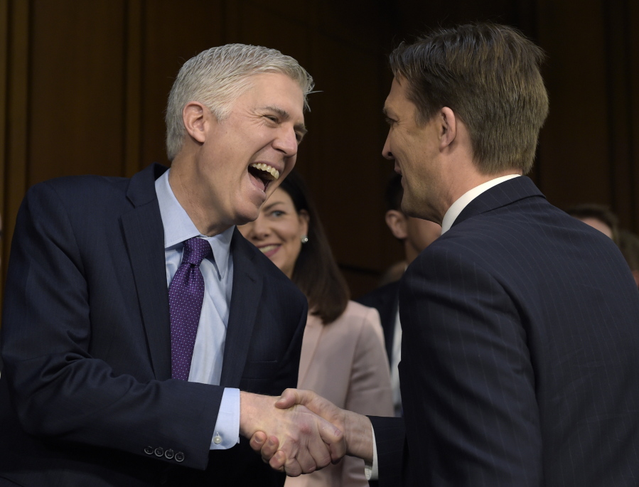Supreme Court Justice nominee Neil Gorsuch, left, shares a laugh with Senate Judiciary Committee member Sen. Ben Sasse, R-Neb.as he arrives on Capitol Hill in Washington for his confirmation hearing before the Senate Judiciary Committee. Former New Hampshire Sen. Kelly Ayotte is at center.