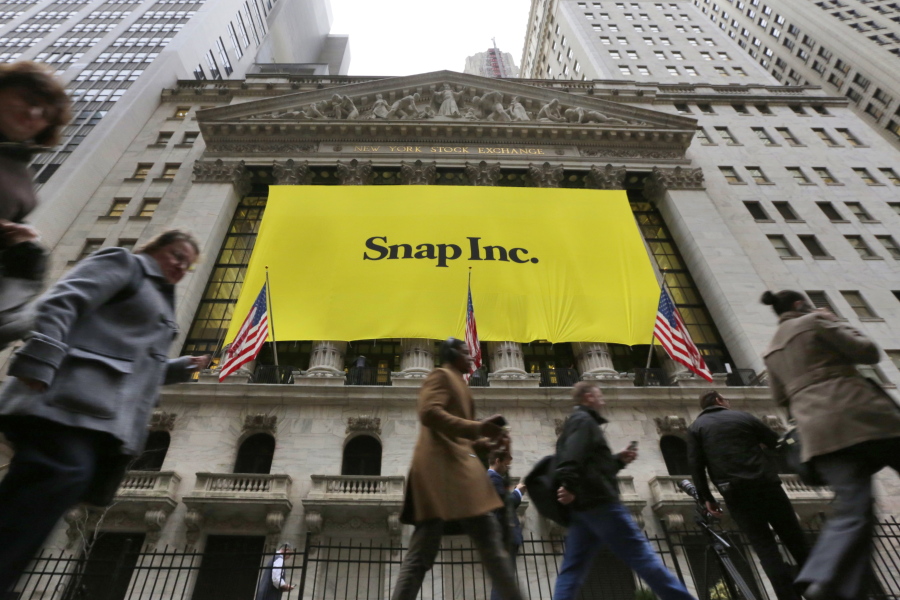 People pass by the New York Stock Exchange after the banner for the Snap Inc. IPO was raised on the building&#039;s facade Wednesday.