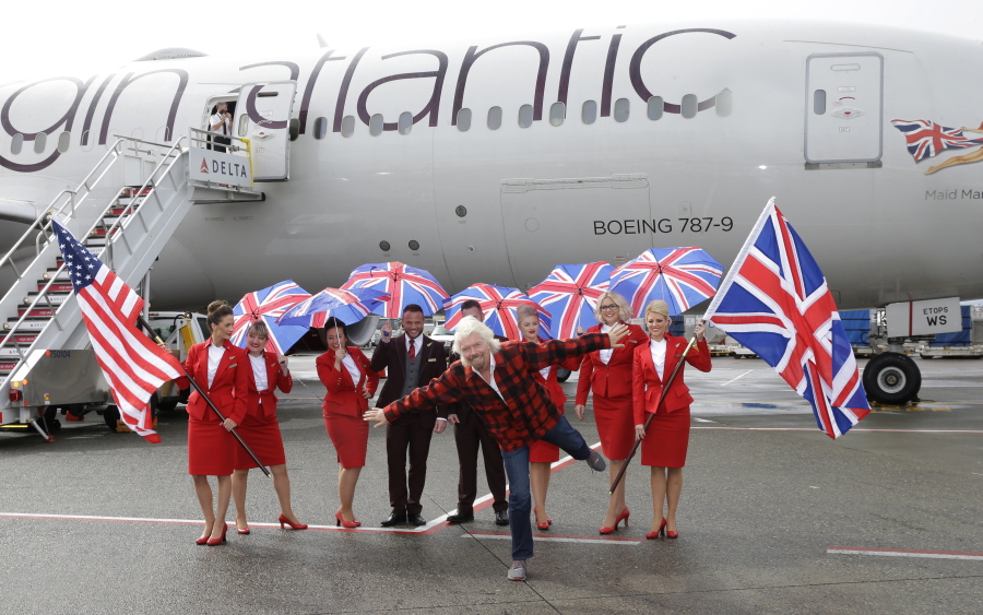 Richard Branson, center, founder of Virgin Atlantic and the Virgin Group, poses for a photo Monday after he arrived on a flight from London to Seattle at Seattle-Tacoma International Airport in Seattle. (Ted S.