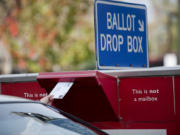 A voter drops off their ballot in the drop box on West 14th Street.