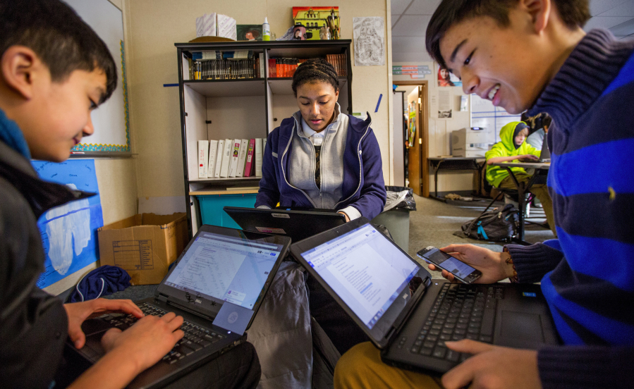 Eighth-grade Technology Access Foundation students Jesse Nguyen, from left, Saana Banks and Nathan Calimlim work on creating a parody of a song that focuses on complaints during the Civil War at the Kent school.