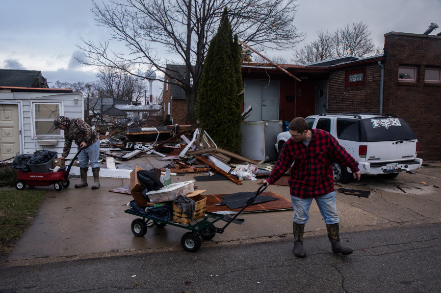 Bryan Blue, left, and Paxson Bentz help move a friend&#039;s belongings March 1, after a tornado hit Naplate, Ill., a village in LaSalle County.
