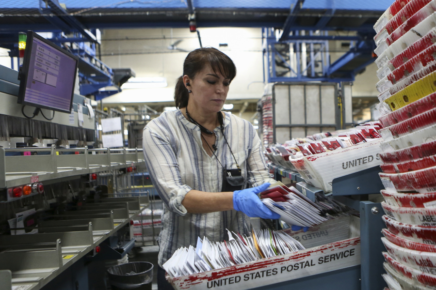 Martha Aguilar, a mail clerk, sorts through letters on last year at the U.S. Post Office in Miami, Fla. (Matias J.