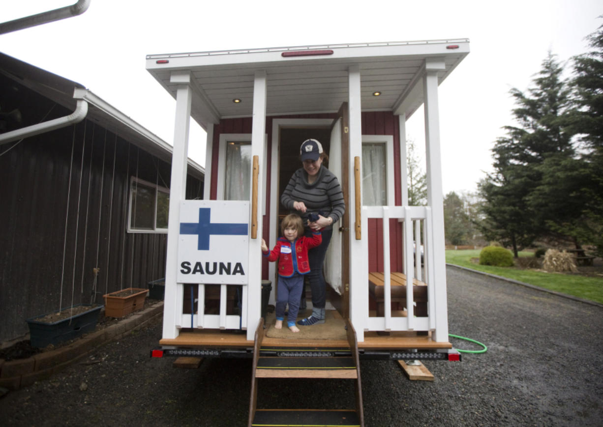 Oliver Murray and his mother, Marita Ghobrial, exit the Traveling Sauna, which made a stop in Battle Ground on Saturday.
