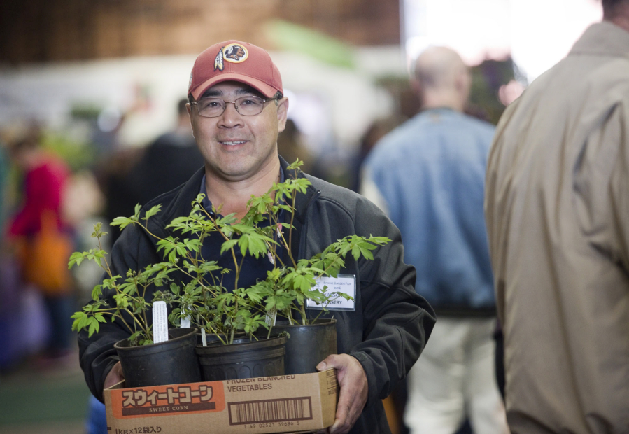 Tee Win holds a box of plants at the 26th annual Home and Garden Idea Fair at the Clark County Event Center at the Fairgrounds in Ridgefield on Saturday.