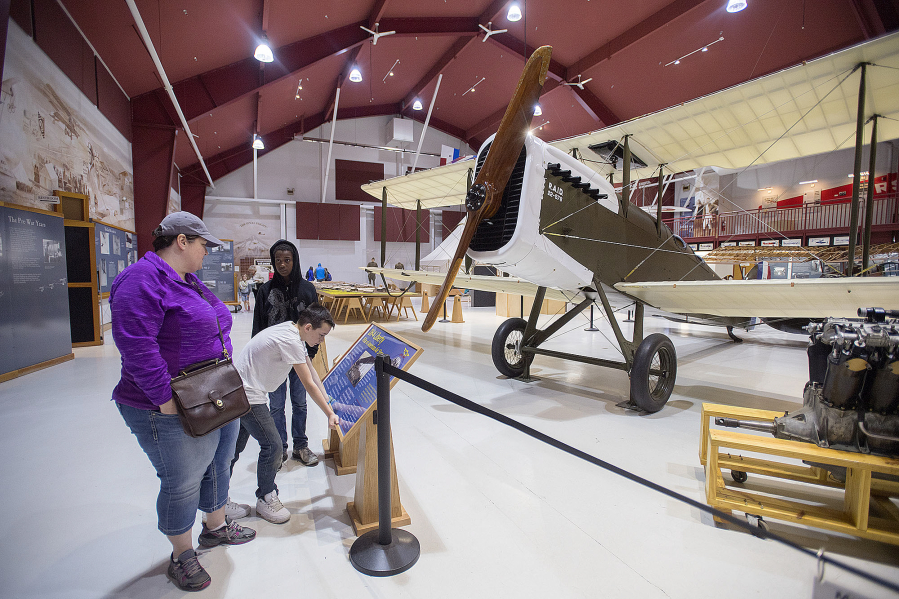 Angela Snead of Portland, left, is joined by Josh Repp, 12, in a white T-shirt, and her son, Jamar Snead, 11, while checking out the DH-4 Liberty biplane on March 28 at Pearson Air Museum.
