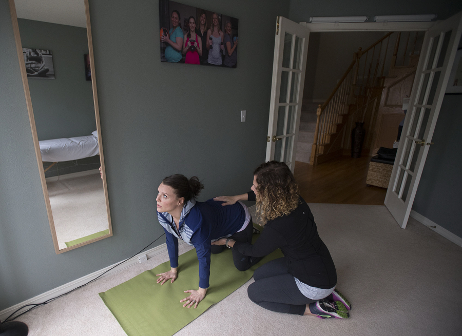 Client Cecelia Mikles, left, works with women&#039;s health physical therapist Christina Trautman during a session Wednesday at Trautman&#039;s Felida home. Mikles is 23 weeks pregnant and is going through Trautman&#039;s Pregnancy and Postpartum Exercise Training program to stay fit during pregnancy and prepare for labor.
