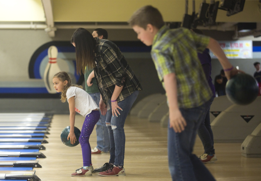 Bethany Nyguyen helps her daughter Lily, 6, bowl at Husted&#039;s Hazel Dell Lanes on Sunday. The event was organized by Autism Empowerment, a local nonprofit organization that serves people on the autism spectrum.