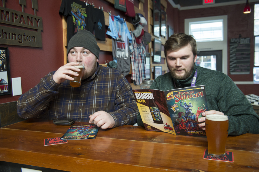 Jake Storgaard, left, takes a sip of the Shadow Shinobi IPA while Sky Cumlander reads the Shadow Shinobi comic book at Loowit Brewing Co. The brewery released the comic book to announce the rebranding of its most popular beer after a copyright dispute.