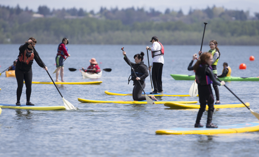 Beginning stand-up paddlers practice during a class at the 25th annual Spring Paddle Festival at Vancouver Lake Sunday. Hundreds came out over the weekend to check out boats and try their hands on the water. (Photos by Randy L.