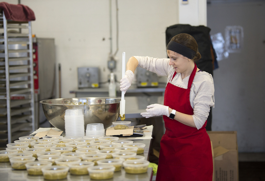 Production/social media assistant Ashley Maginnis helps distribute pistachio nut butter into containers. The butters are sold at various health food and alternative grocers in the Portland and Seattle markets.