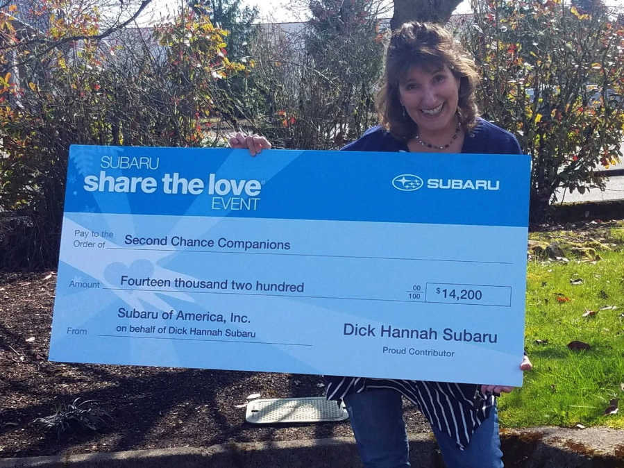 Battle Ground: Second Chance Companions volunteer Sandy Prue displays a check for $14,200 from Dick Hannah Subaru.