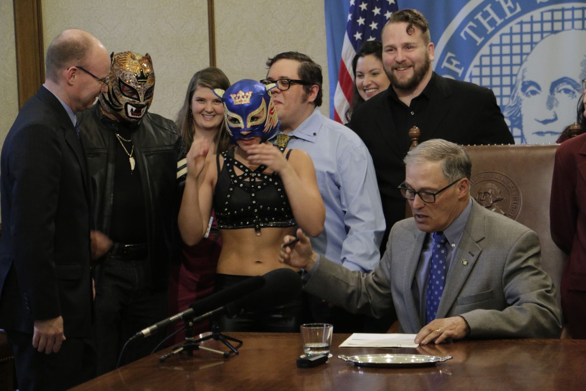 Washington Gov. Jay Inslee talks with supporters of theatrical wrestling before signing a bill that creates a license for theatrical wrestling schools, on Monday, April 17, 2017 in Olympia, Wash. Under the measure, any licensed theatrical wrestling school would be allowed to schedule a certain number of public performances.