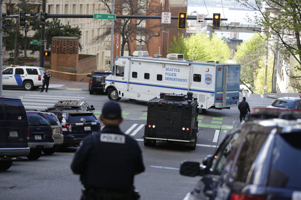 A Seattle Police vehicle turns near the scene of a shooting involving several police officers in downtown Seattle, Thursday, April 20, 2017. (AP Photo/Ted S.
