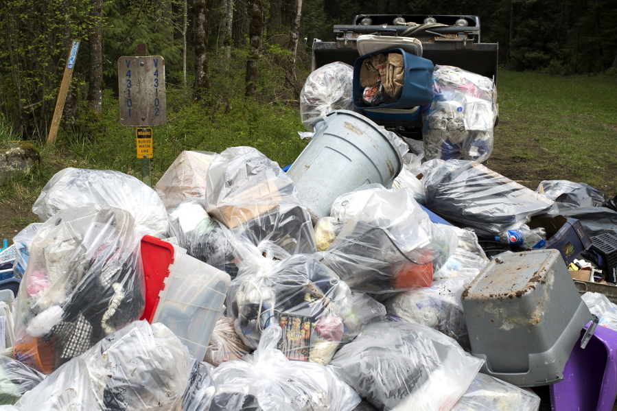 Trash piles up along the Waterline Trail at Whatcom Falls Park as Bellingham Parks and Recreation employees clean up a homeless camp in the forest in Bellingham.