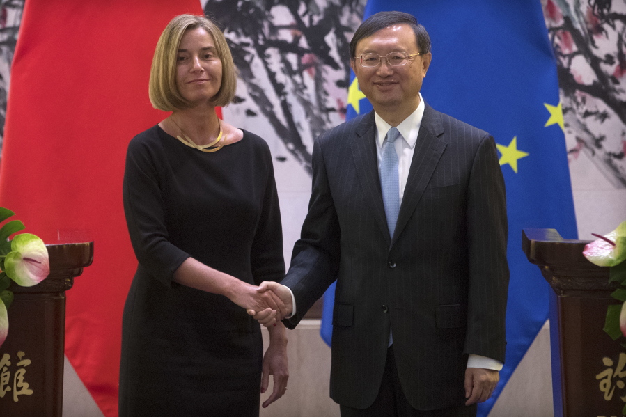 Federica Mogherini, High Representative of the European Union for Foreign Affairs and Security Policy, left, and Chinese State Councilor Yang Jiechi shake hands as they pose for a photo at the end of a joint press conference at the Diaoyutai State Guesthouse in Beijing on Wednesday.
