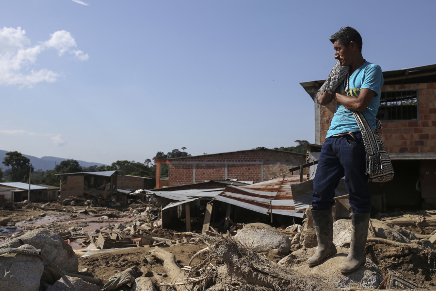 A man stands over boulders at a destroyed neighborhood in Mocoa, Colombia, on Tuesday. Colombian authorities said at least 273 people were killed when rivers surrounding Mocoa overflowed and sent a wall of water and debris surging through the city over the weekend. The death toll was expected to rise since many more were missing and bodies are still being found.