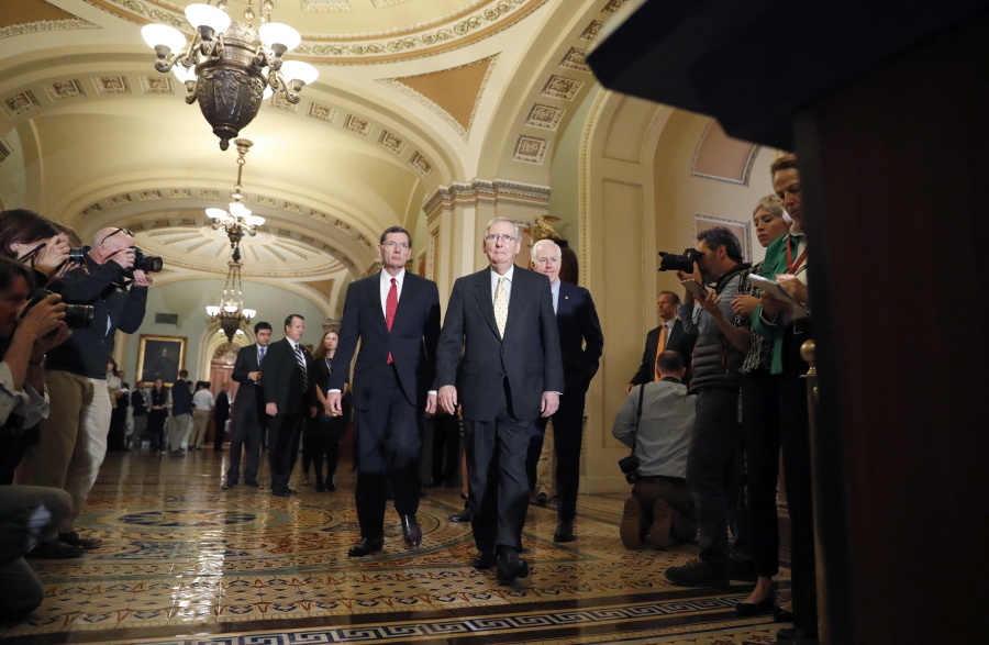 Senate Majority Leader Mitch McConnell of Ky., center, flanked by Sen. John Barrasso, R-Wyo., left, and Senate Majority Whip John Cornyn of Texas, arrives for a media availability following a policy luncheon, Tuesday on Capitol Hill in Washington.
