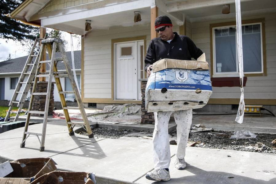 Tony Edwards, a painter for Shelby &amp; Miguelena Construction, carries debris from a job site in Roseburg, Ore. After the 2007 housing market crash, many skilled workers left Douglas County to find work, placing people such as Edwards in high demand.