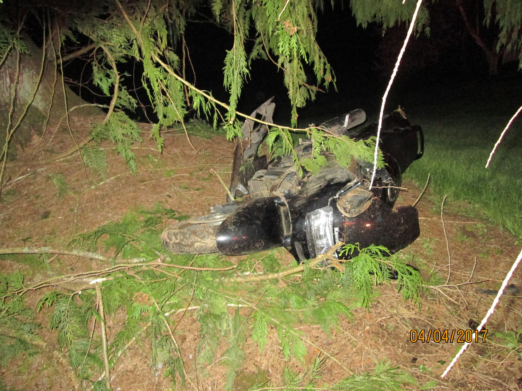 A motorcycle lies near a tree at the scene of a Tuesday night crash.