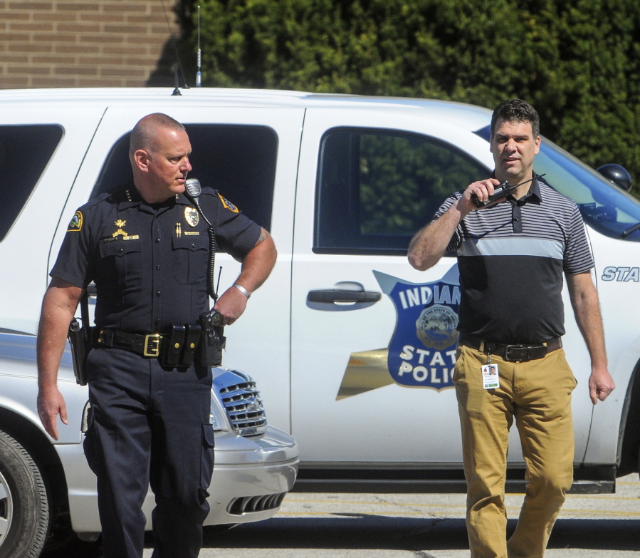 Terre Haute Police Chief John Plasse, left, and Tom Balitewicz, the director of student services for the Vigo County School Corporation, walk out of Terre Haute North High School during a lockdown at the school, Friday, April 7, 2017, in Terre Haute, Ind. Dozens of police officers stormed the school following a reported bomb threat, but law enforcement later said they thought it was a hoax and that everyone was safe.