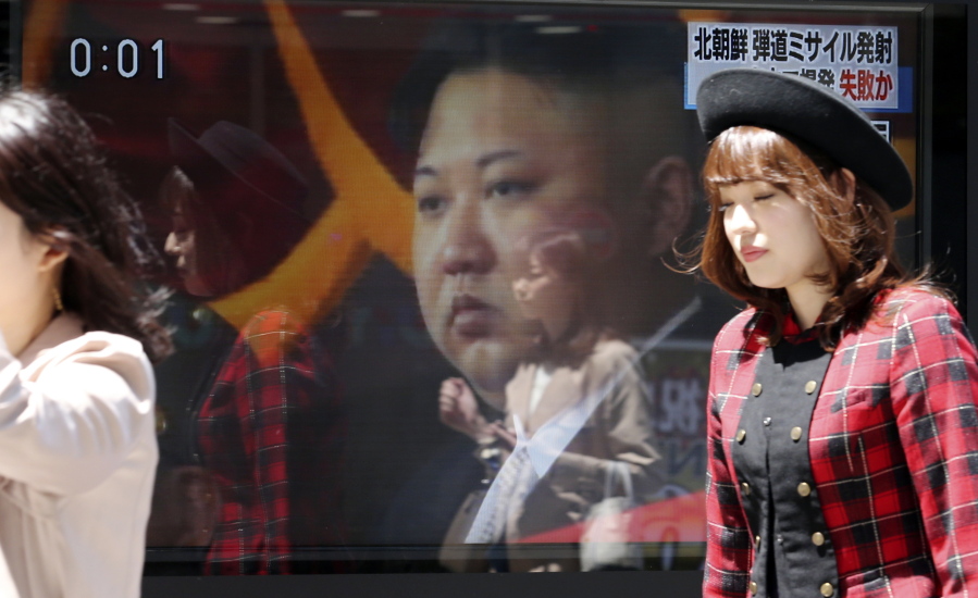 People walk past a TV showing an image of North Korean leader Kim Jong Un during a report on North Korea&#039;s missile test Saturday in Tokyo.