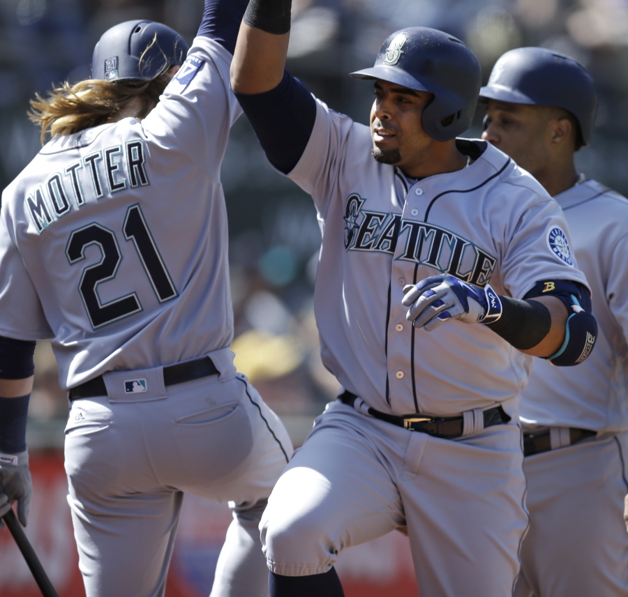 Nelson Cruz, right, celebrates with Taylor Motter (21) after hitting a three run home run in the seventh inning of Seattle&#039;s win in Oakland.