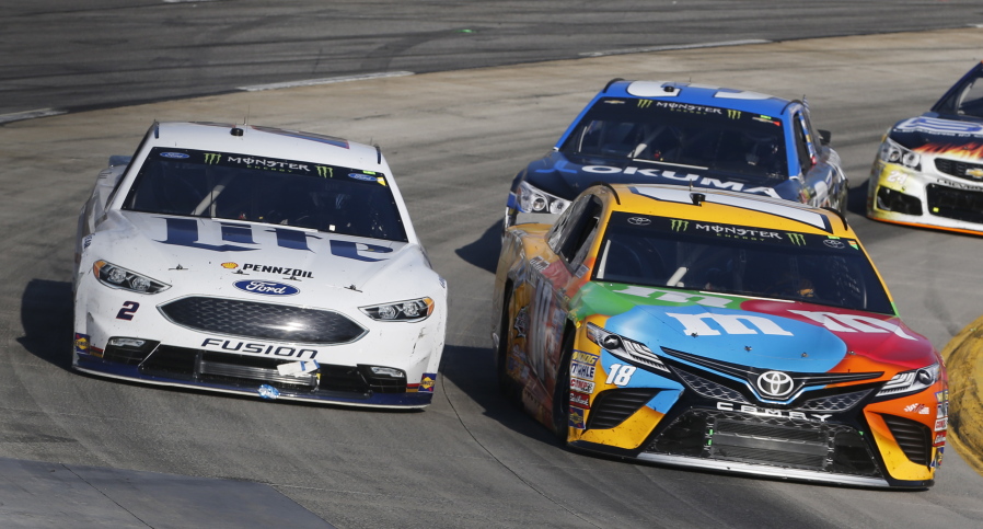 Brad Keselowski (2) and Kyle Busch (18) battle for position in Turn 4 during the NASCAR Cup Series auto race at Martinsville Speedway in Martinsville, Va., Sunday, April 2, 2017. Keselowski won the race.
