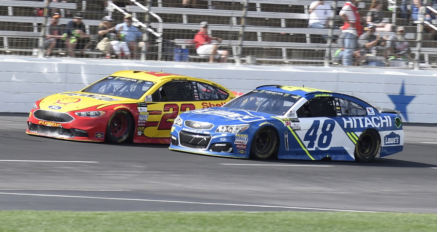 Jimmie Johnson (48) passes Joey Logano (22) on the front stretch with late in the NASCAR Cup Series auto race at Texas Motor Speedway in Fort Worth, Texas, Sunday, April 9, 2017. Johnson won the race.