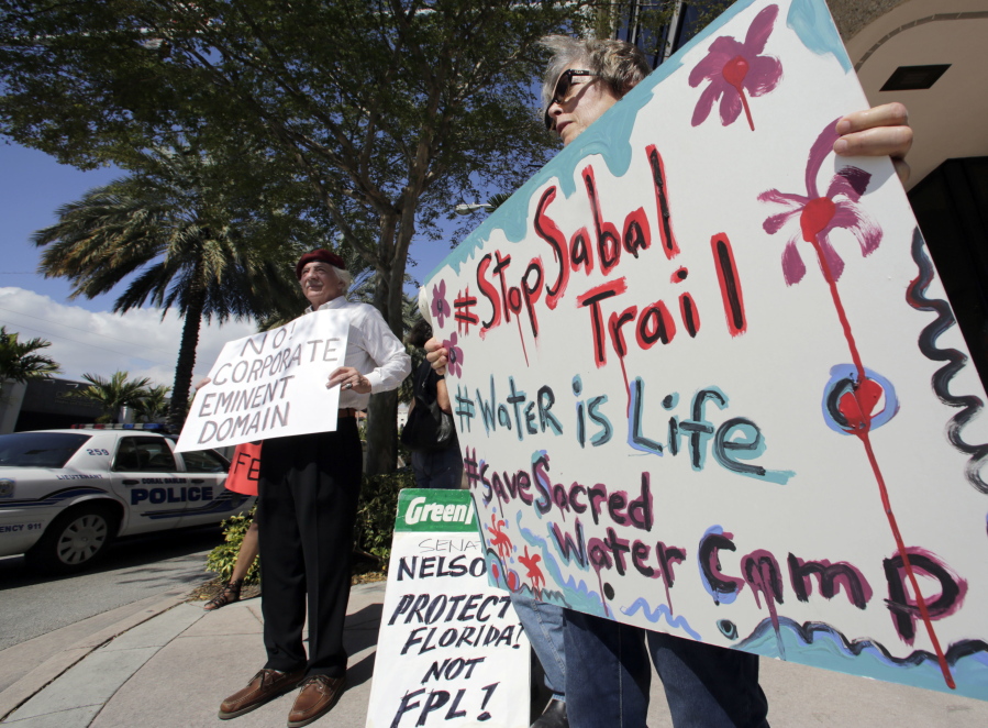 Sabal Trail pipeline protesters hold signs against the pipeline project Feb. 14 in front of the office of U.S. Sen. Bill Nelson in Coral Gables, Fla. The Sabal Trail is an underground natural gas pipeline project from Alabama to Florida.
